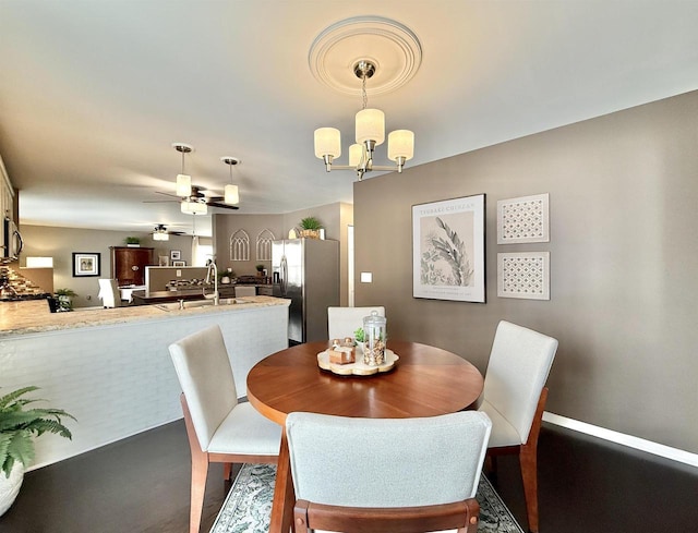 dining area featuring ceiling fan with notable chandelier