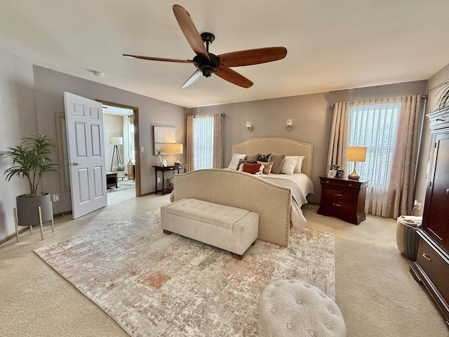 carpeted bedroom featuring multiple windows and ceiling fan