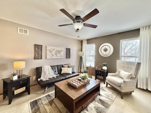 carpeted living room featuring ceiling fan and a wealth of natural light