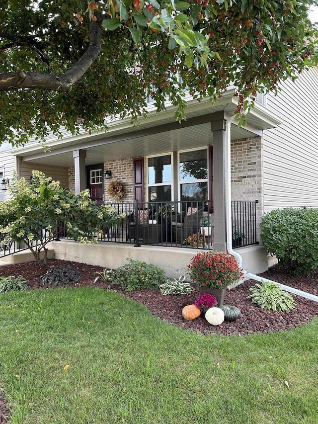 doorway to property with a yard and a porch