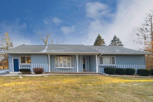 ranch-style home featuring covered porch and a front yard