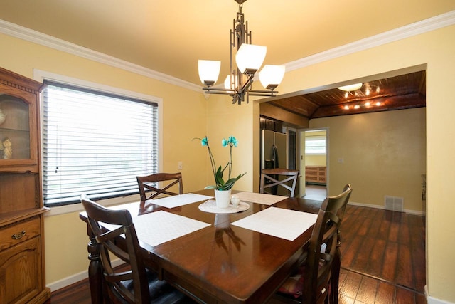 dining area featuring crown molding, dark hardwood / wood-style floors, a wealth of natural light, and an inviting chandelier