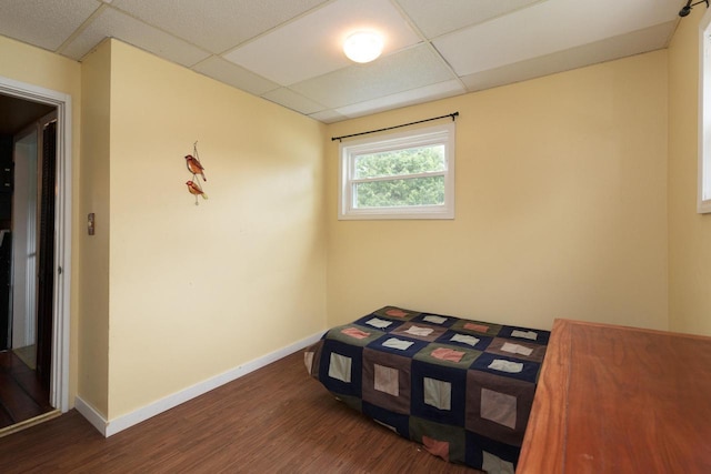 bedroom featuring dark hardwood / wood-style flooring and a drop ceiling