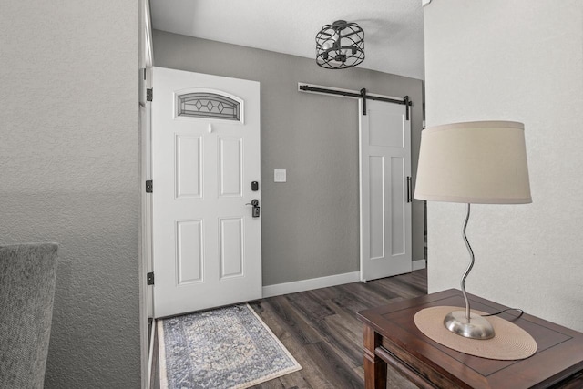 entryway featuring dark wood-type flooring and a barn door