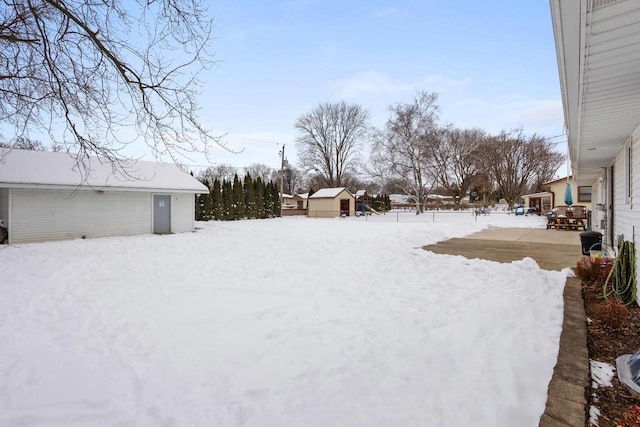 yard layered in snow with a shed