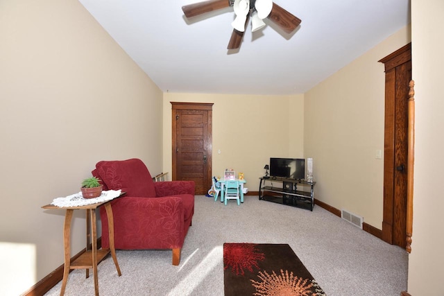 living area with carpet floors and ceiling fan