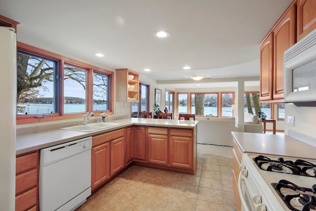 W5553 Oak Park Rd, Elkhorn, WI 53121 - kitchen featuring white appliances, light tile patterned floors, sink, a water view, and kitchen peninsula