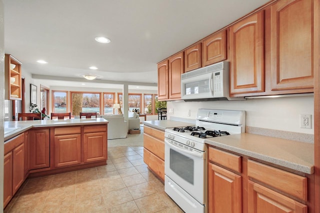 W5553 Oak Park Rd, Elkhorn, WI 53121 - kitchen with kitchen peninsula, white appliances, and light tile patterned flooring