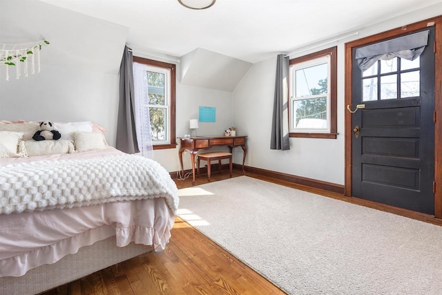 bedroom with multiple windows, hardwood / wood-style flooring, and vaulted ceiling