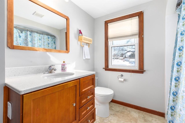 bathroom with toilet, vanity, and walk in shower