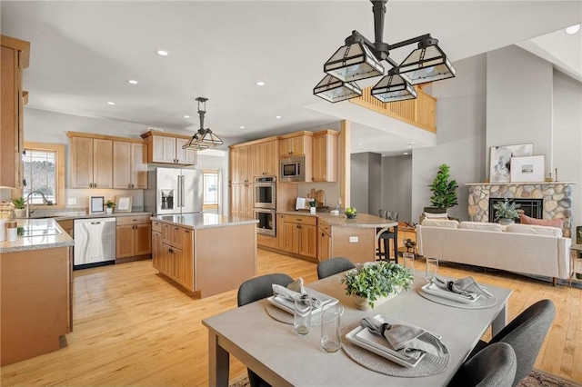 dining area with a fireplace, sink, and light hardwood / wood-style floors