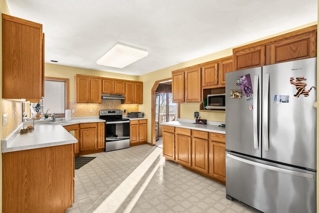 kitchen featuring sink, appliances with stainless steel finishes, and decorative backsplash