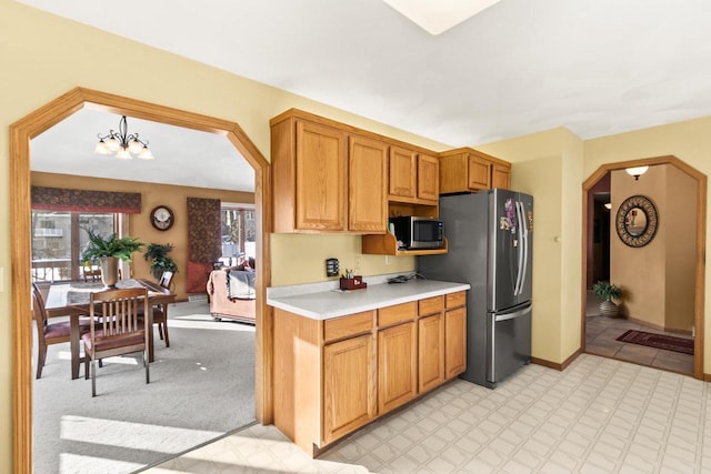 kitchen featuring appliances with stainless steel finishes, an inviting chandelier, and pendant lighting