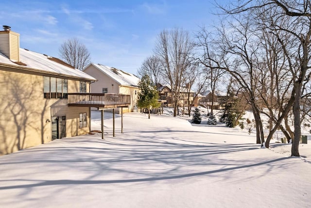 yard covered in snow featuring a wooden deck