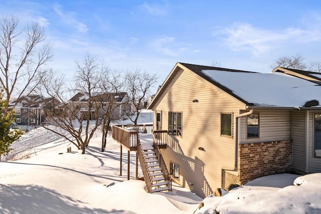 snow covered property with a wooden deck