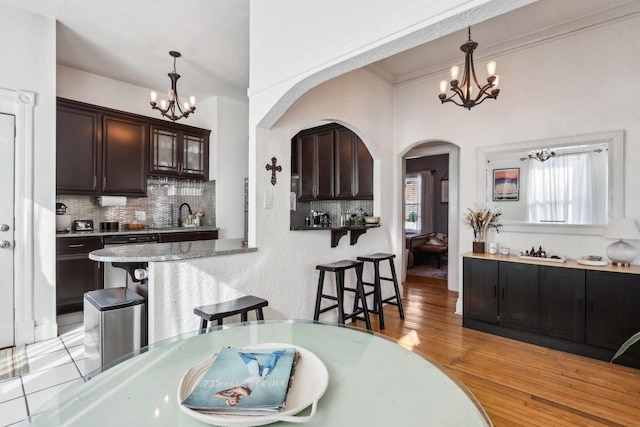 dining room with ornamental molding, sink, light hardwood / wood-style floors, and a chandelier