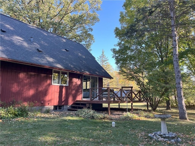 rear view of property with a lawn and a wooden deck