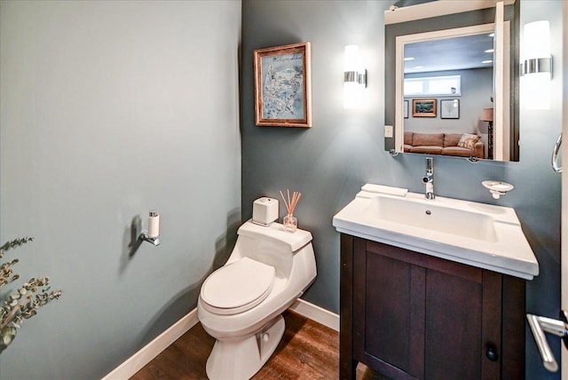 bathroom with hardwood / wood-style flooring, vanity, and toilet