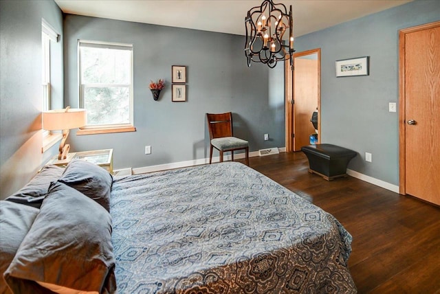 bedroom with dark hardwood / wood-style flooring and an inviting chandelier