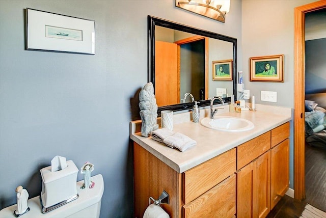 bathroom with toilet, vanity, and hardwood / wood-style floors