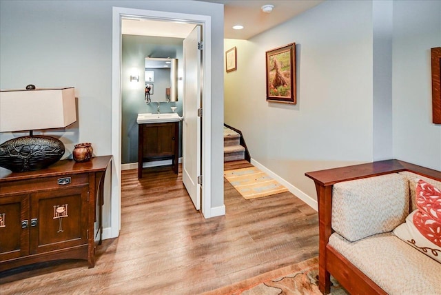 corridor with sink and light wood-type flooring