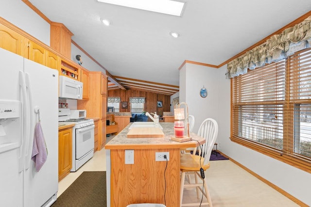 kitchen with vaulted ceiling with skylight, a breakfast bar area, white appliances, crown molding, and a kitchen island with sink