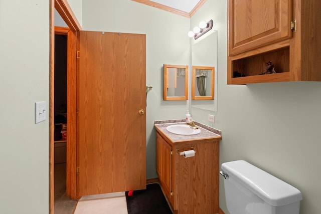 bathroom with ornamental molding, vanity, toilet, and a skylight