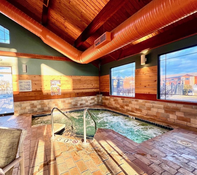 pool at dusk with an indoor in ground hot tub