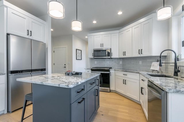 kitchen with white cabinetry, appliances with stainless steel finishes, and hanging light fixtures