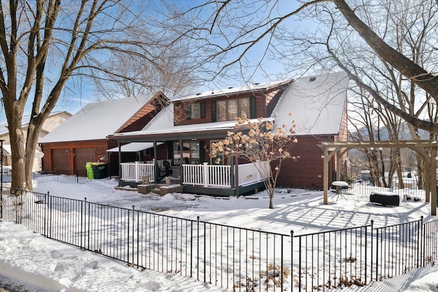 view of front of home featuring fence, covered porch, and an attached garage