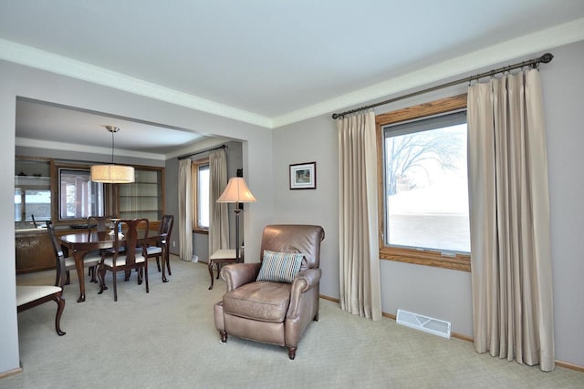 sitting room with light colored carpet and ornamental molding