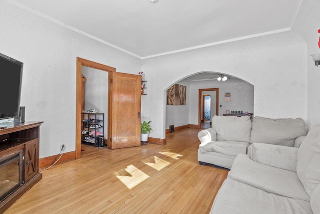 living room with light wood-type flooring and ornamental molding