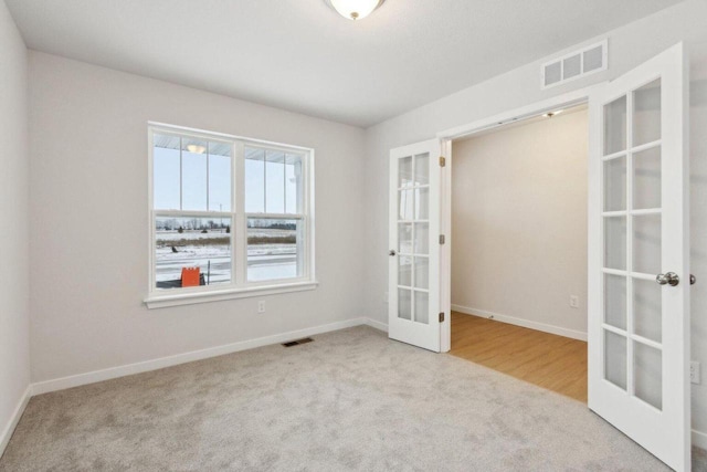 empty room with light carpet and french doors