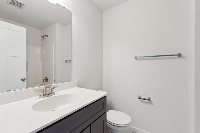 bathroom featuring vanity, toilet, and walk in shower