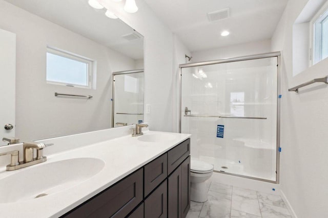 bathroom featuring vanity, a shower with door, and toilet