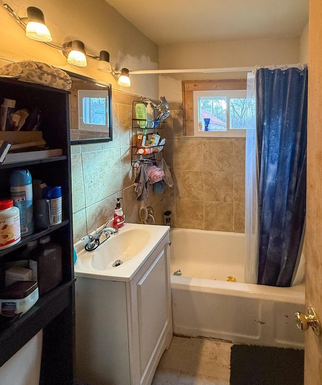 bathroom with shower / tub combo with curtain, tile walls, decorative backsplash, and vanity