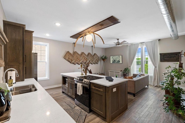 kitchen with sink, dark wood-type flooring, dark brown cabinets, and stainless steel appliances