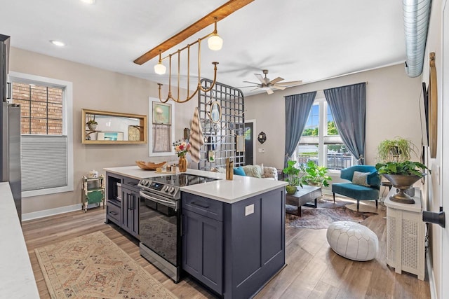 kitchen with stainless steel electric range, light hardwood / wood-style floors, pendant lighting, and a kitchen island