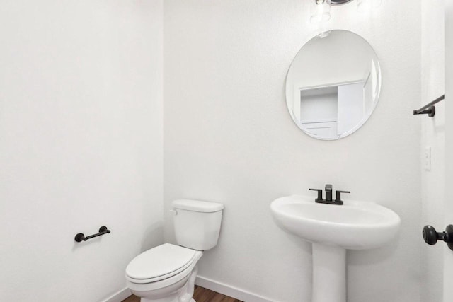 bathroom featuring toilet and wood-type flooring