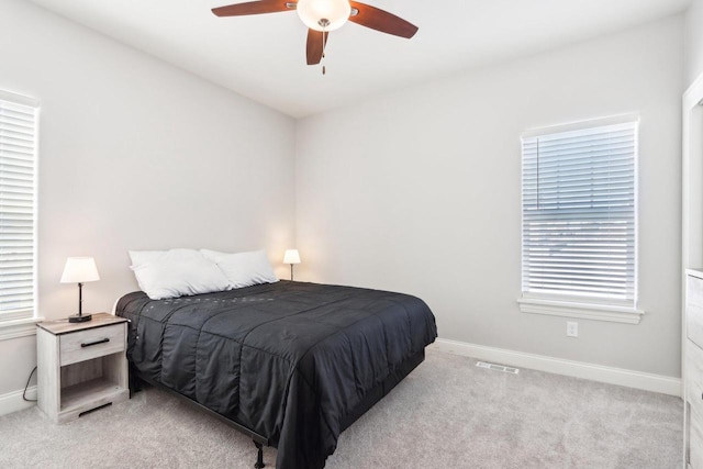 bedroom featuring light carpet, baseboards, visible vents, and ceiling fan