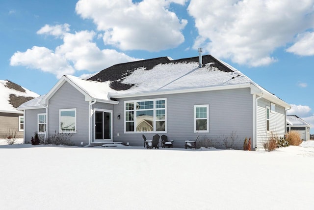 view of snow covered back of property