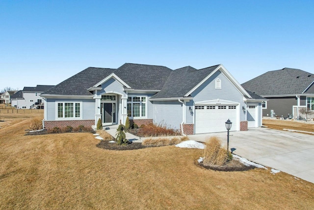 view of front of property with an attached garage, a front lawn, and brick siding