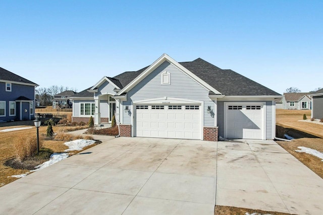 view of front of house featuring a garage, brick siding, driveway, and a shingled roof