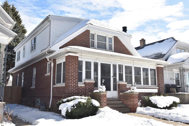 exterior space with a sunroom and brick siding