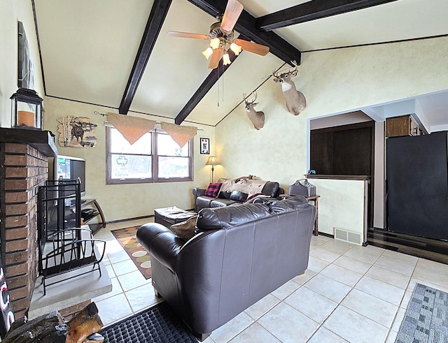 living room featuring ceiling fan, light tile patterned flooring, vaulted ceiling with beams, and a brick fireplace