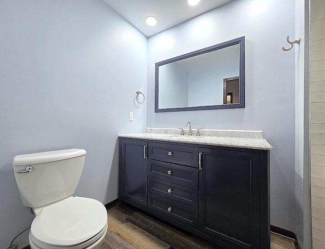 bathroom featuring toilet, vanity, and wood-type flooring