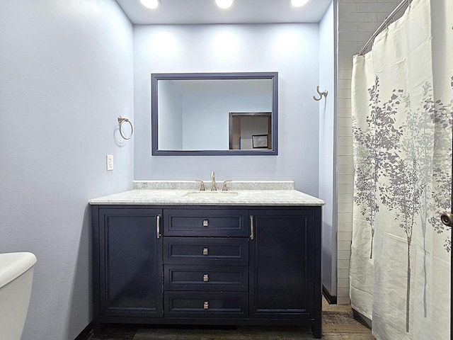 bathroom featuring hardwood / wood-style flooring, vanity, a shower with shower curtain, and toilet