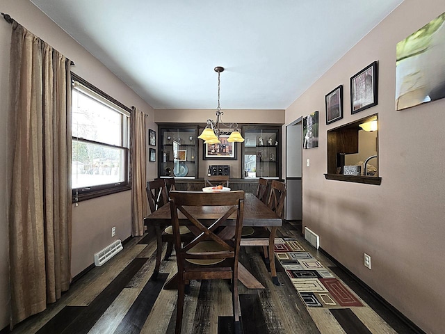 dining space with a chandelier and dark hardwood / wood-style floors