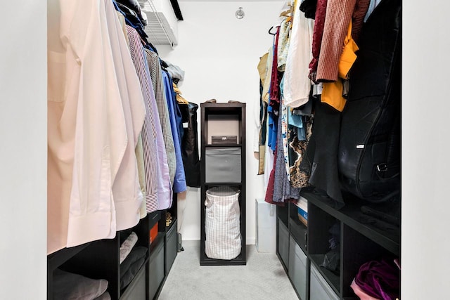 walk in closet featuring light colored carpet