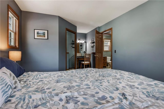 bedroom featuring multiple windows and connected bathroom